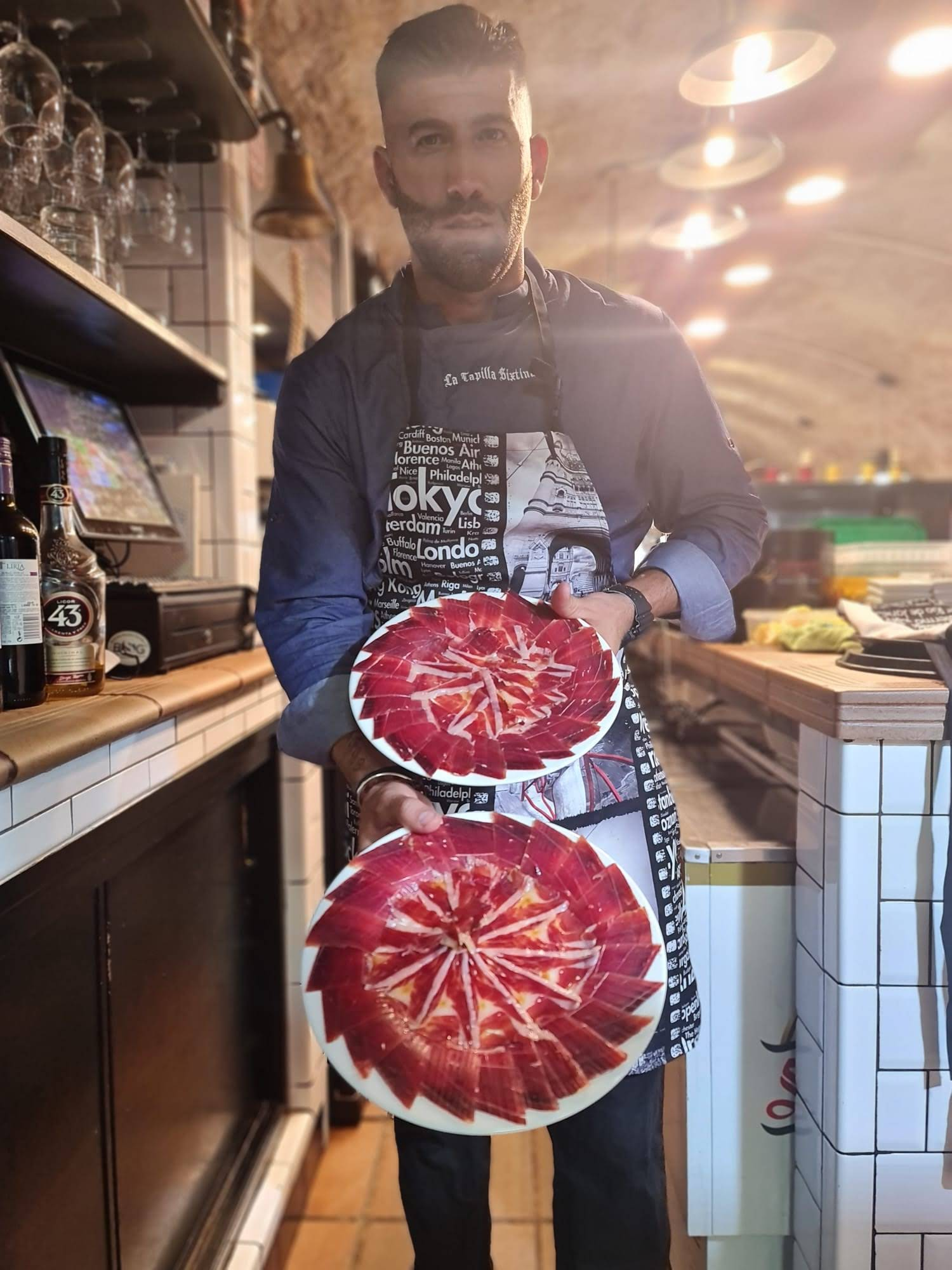 Server presenting a plate of Iberian ham